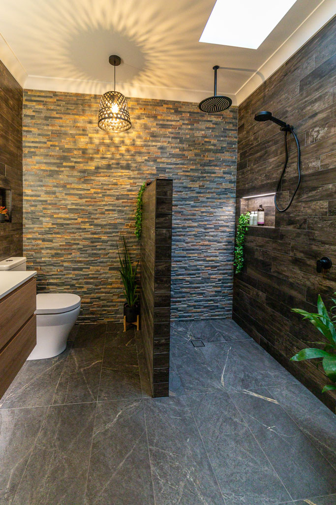 Ensuite bathroom in Alstonville NSW featuring  dark stone tiles & wood plank tiles. LED lighting and skylight.