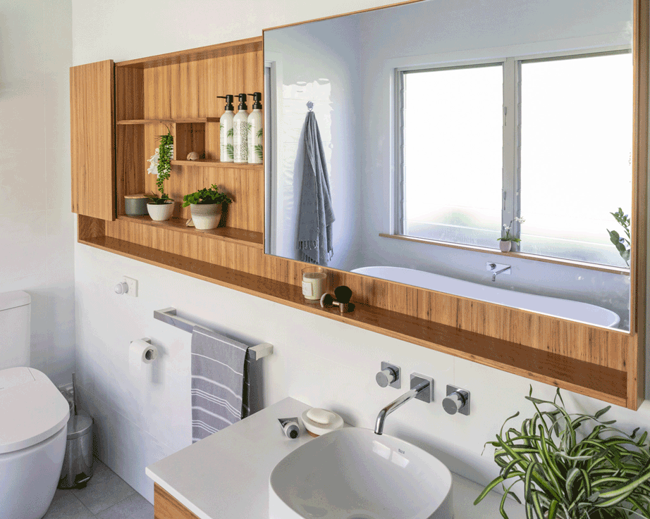 bathroom renovation in Lismore NSW by Northern Rivers Bathroom Renovations featuring blackbutt mirror cabinet with shelves and sliding mirror door and blackbutt wall hung vanity.