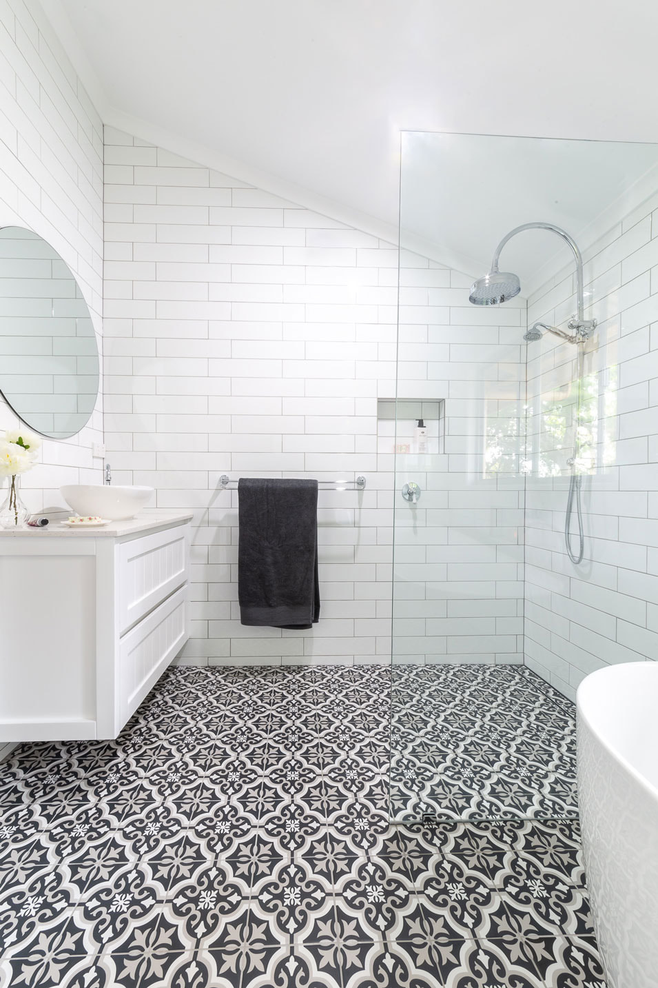 Bathroom remodel in Lismore by Northern RIvers Bathroom Renovations. Country cottage style with white subway walls using light grey grout, a white and black encaustic floor tile, hampton wall hung draw vanity, traditional style tapware and free standing bath.