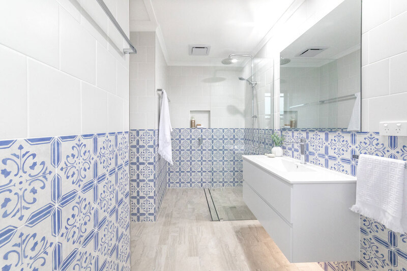 Ensuite bathroom addition to main bedroom in Goonellabah by Northern Rivers Bathroom Renovations. Features Blue & White feature tiles, timber look floor tiles, white wall hung vanity and walk in shower.