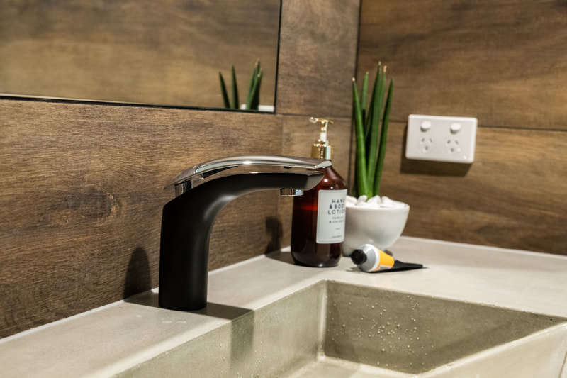 Black tapware and concrete vanity top in an industrial bathroom design in Alstonville NSW Australia