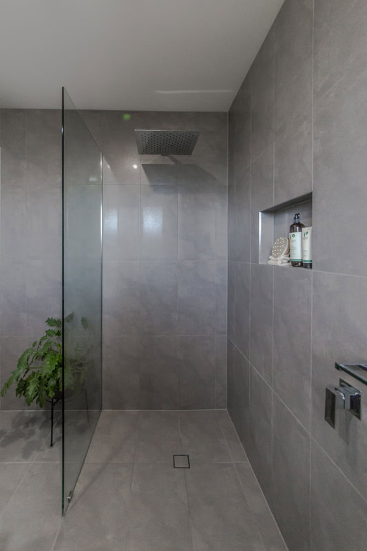 Walk in shower with grey porcelain wall and floor tiles in Wollongbar NSW by Northern Rivers Bathroom Renovations Lismore