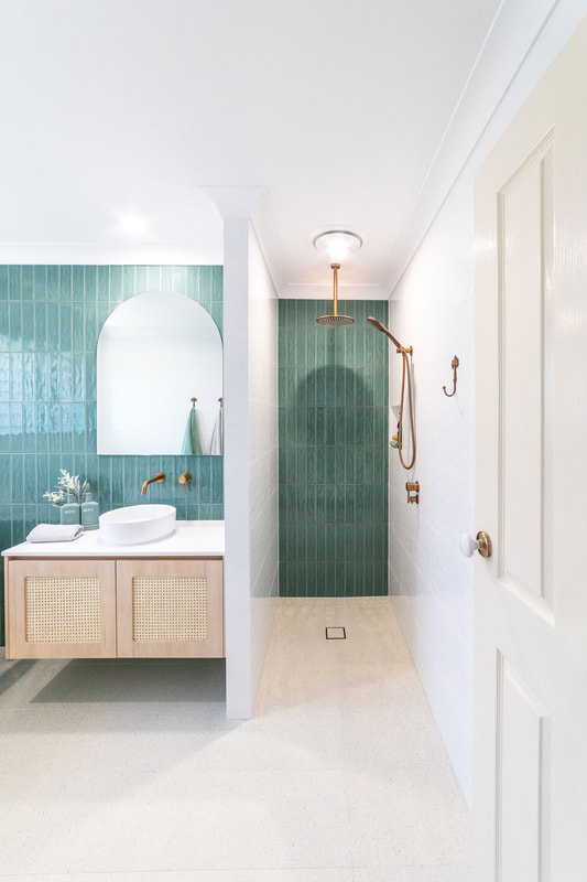coastal bathroom style in Skennars Head bathroom renovation  by Northern Rivers Bathroom Renovations. with sage green subway tile on vanity wall. Light timber laminate vanity with rattan doors, stone benchtop, above counter basin, brushed copper tapware and open walk in shower.
