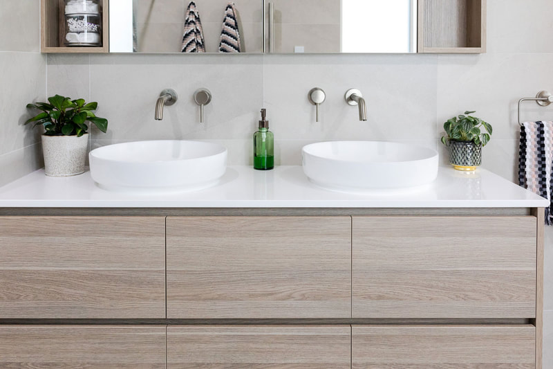 Twin vanity basins,brushed nickle tapware and white stone benchtop by Northern Rivers Bathroom Renovations NSW 2480
